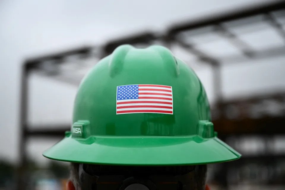 A US flag is displayed on a construction worker's safety helmet during a topping out ceremony for the Midfield Satellite Concourse (MSC) Terminal Expansion project under construction at Los Angeles International Airport (LAX) in Los Angeles, California, on January 17, 2024. LAX, one of the busiest US airports, is undergoing major upgrades as part of a $30 billion capital improvement. (Photo by Patrick T. Fallon / AFP) (Photo by PATRICK T. FALLON/AFP via Getty Images),